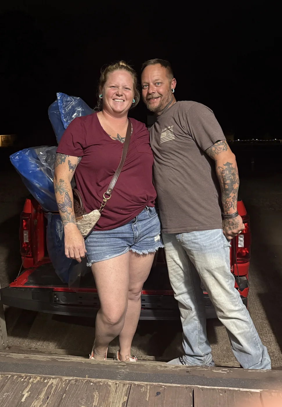 Happy customers picking up a mattress at night